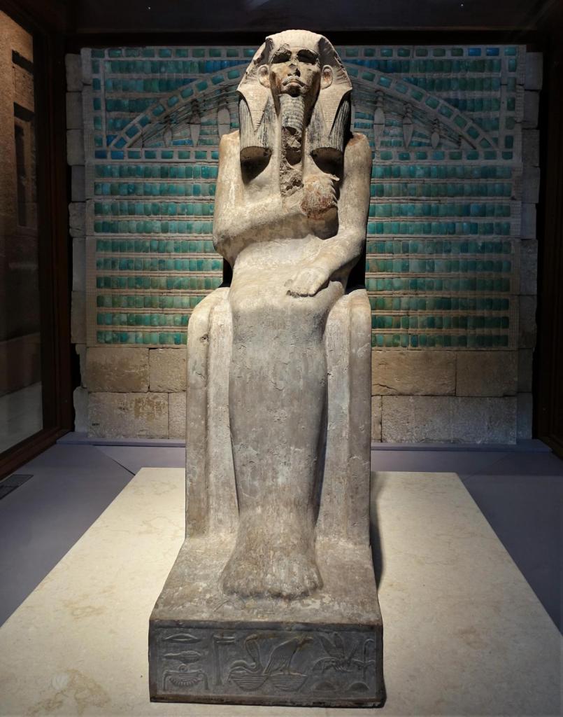 Kairo: Ägyptisches Museum - Statue von Djoser [Kalkstein Sakkara um 2660], dahinter Kachelwand der Stufenpyramide [Kalkstein Sakkara] (2023)