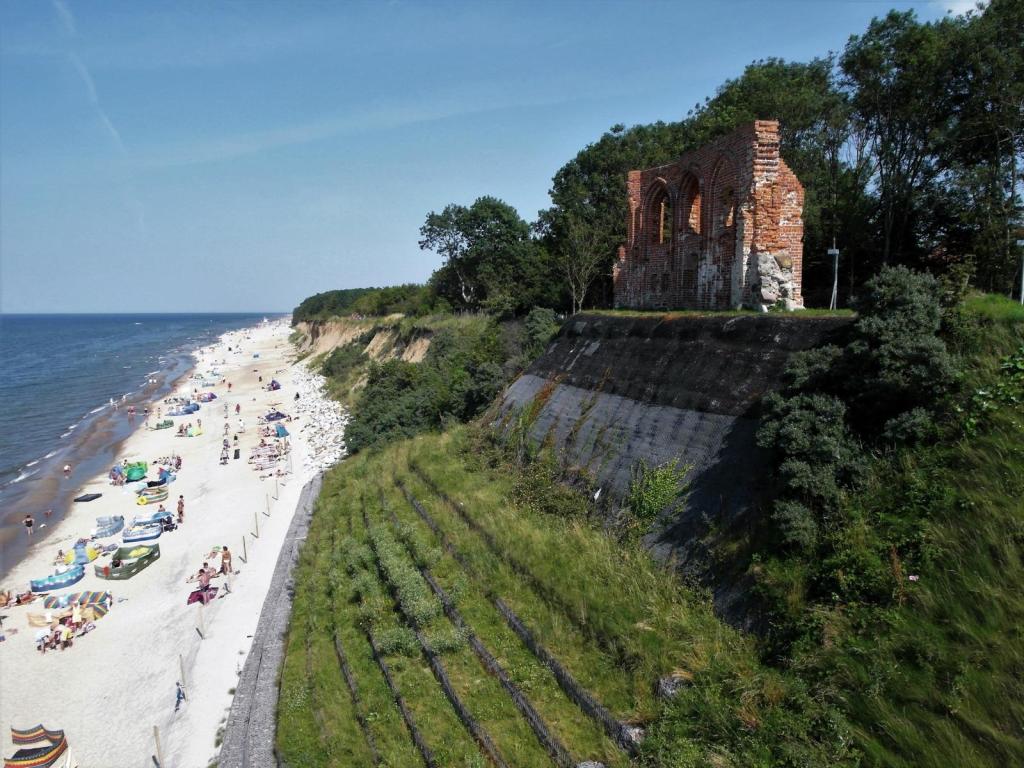 Hoff [poln. Tręsacz]: Steilküste - durch Abtragung [Abrasion] weitgehend zerstörte Kirche (2012)